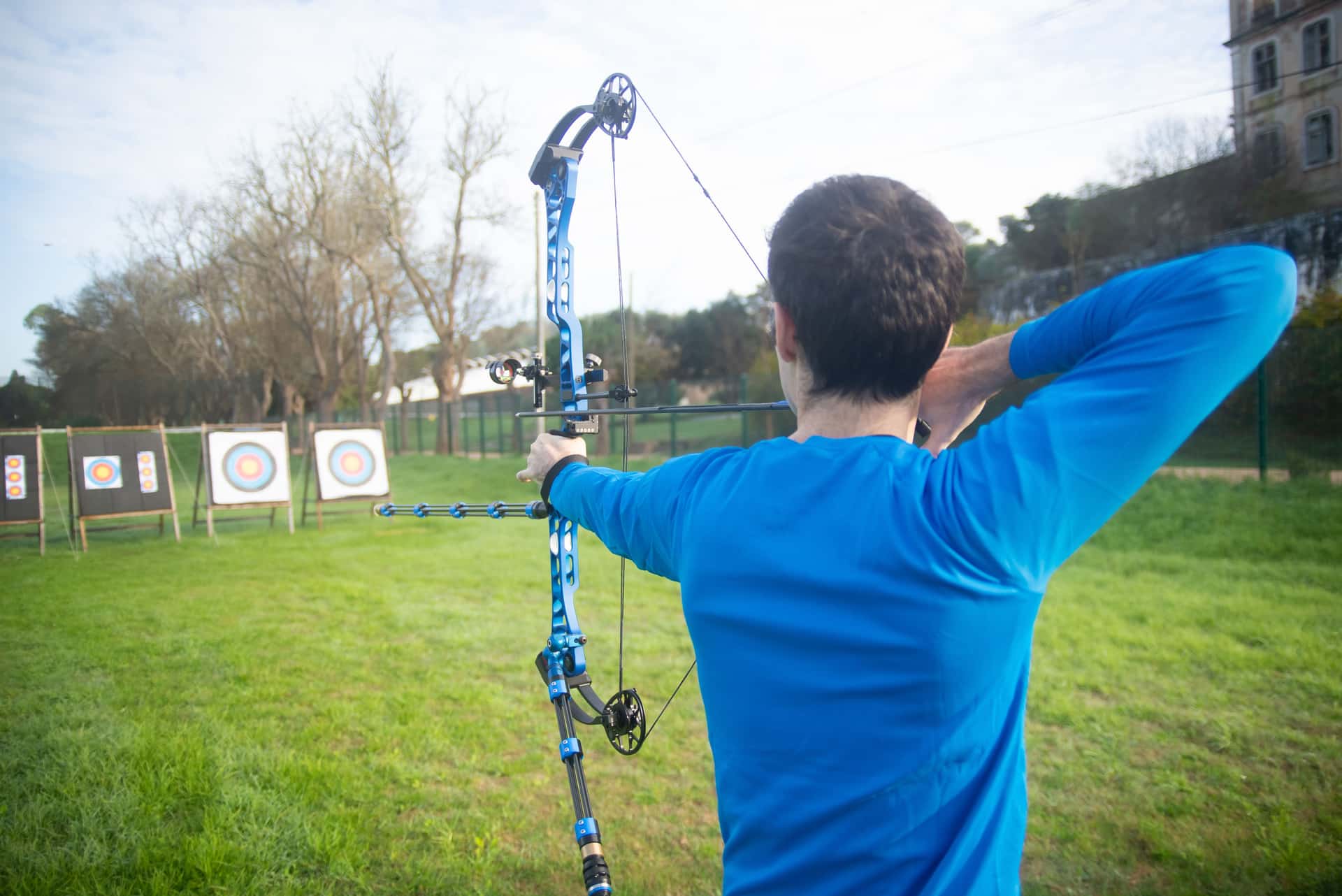 A bowhunter at full draw with a compound bow in the woods